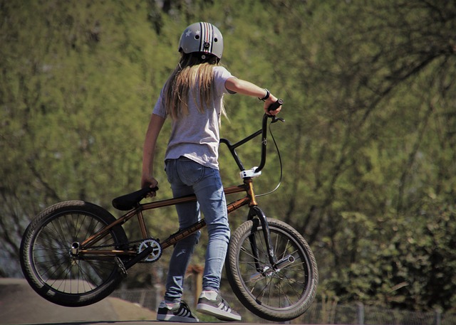 Young girl standing with her BMX bike on a trail