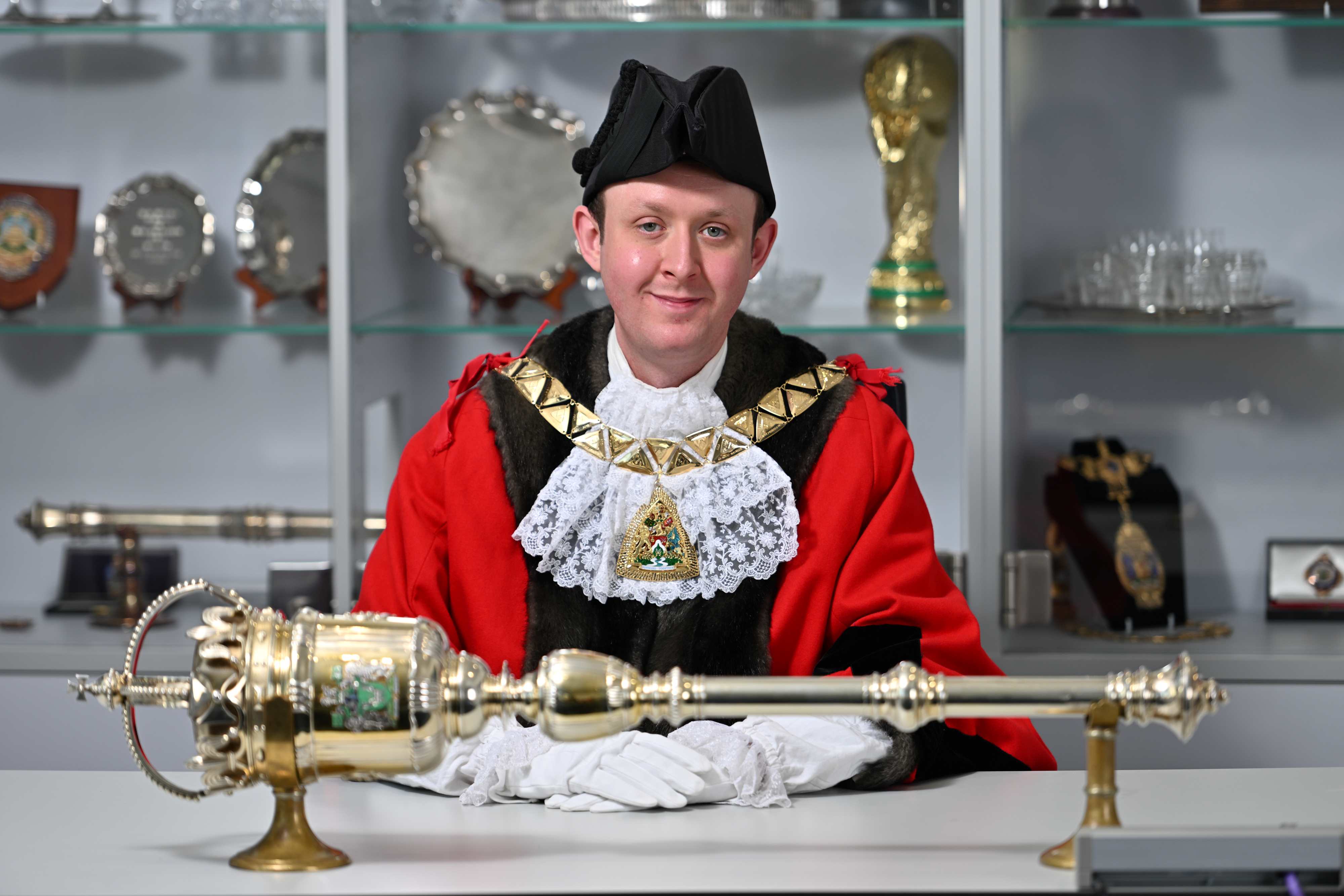 Councillor Ryan Hack sitting at a table in his majoral robes during his Mayor making ceremony