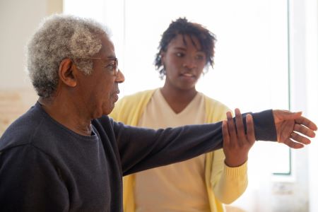 Man being shown how to do stretching exercises