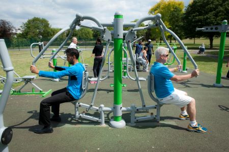 Two people exercising at an outdoor gym