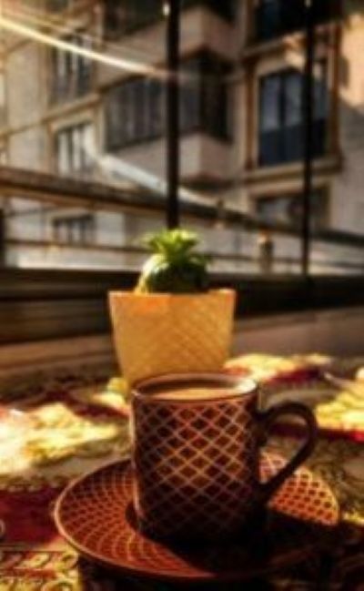 Image of a coffee cup and a small plant next to a window