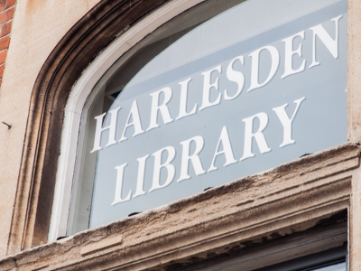 A picture of the front of a building with a sign that reads Harlesden Library