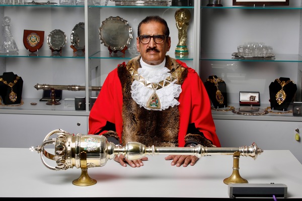 Councillor Tariq Dar sitting at desk with Mayoral sceptre