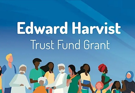 Image of a group of people standing below the text Eward Harvist trust Fund Grant