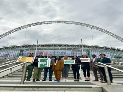 people holding posters outside on the steps of Wembley stadium