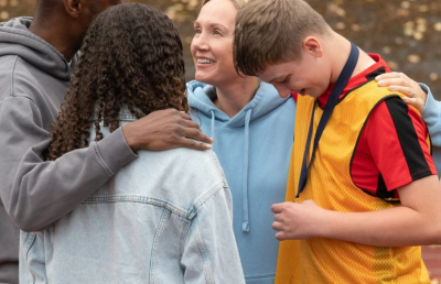 a family hugging each other after foster son wins medal in race