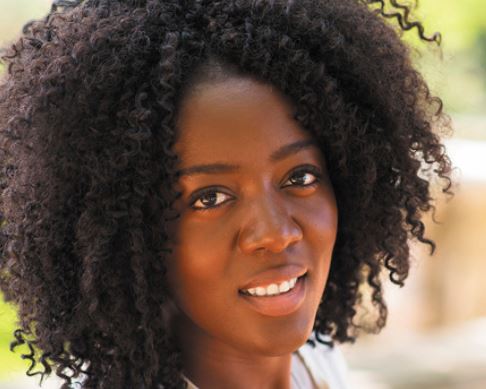 woman with curly hair looking towards camera