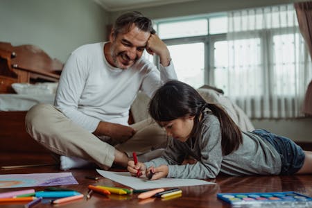 image of father and daughter sitting on floor, drawing
