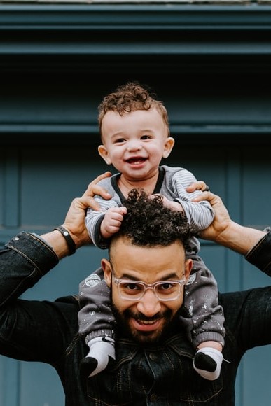 man with a small child on his shoulders