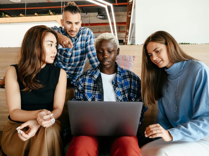 Mixed group of four looking at laptop