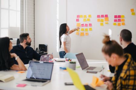 Group of people during a meeting with sticky notes on the wall