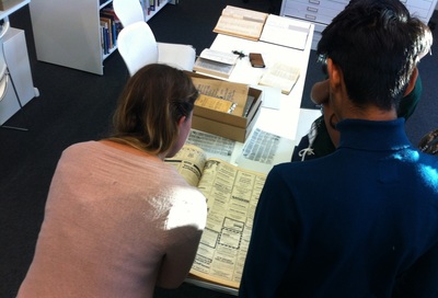 A view over the shoulder of two people looking at the museum achives