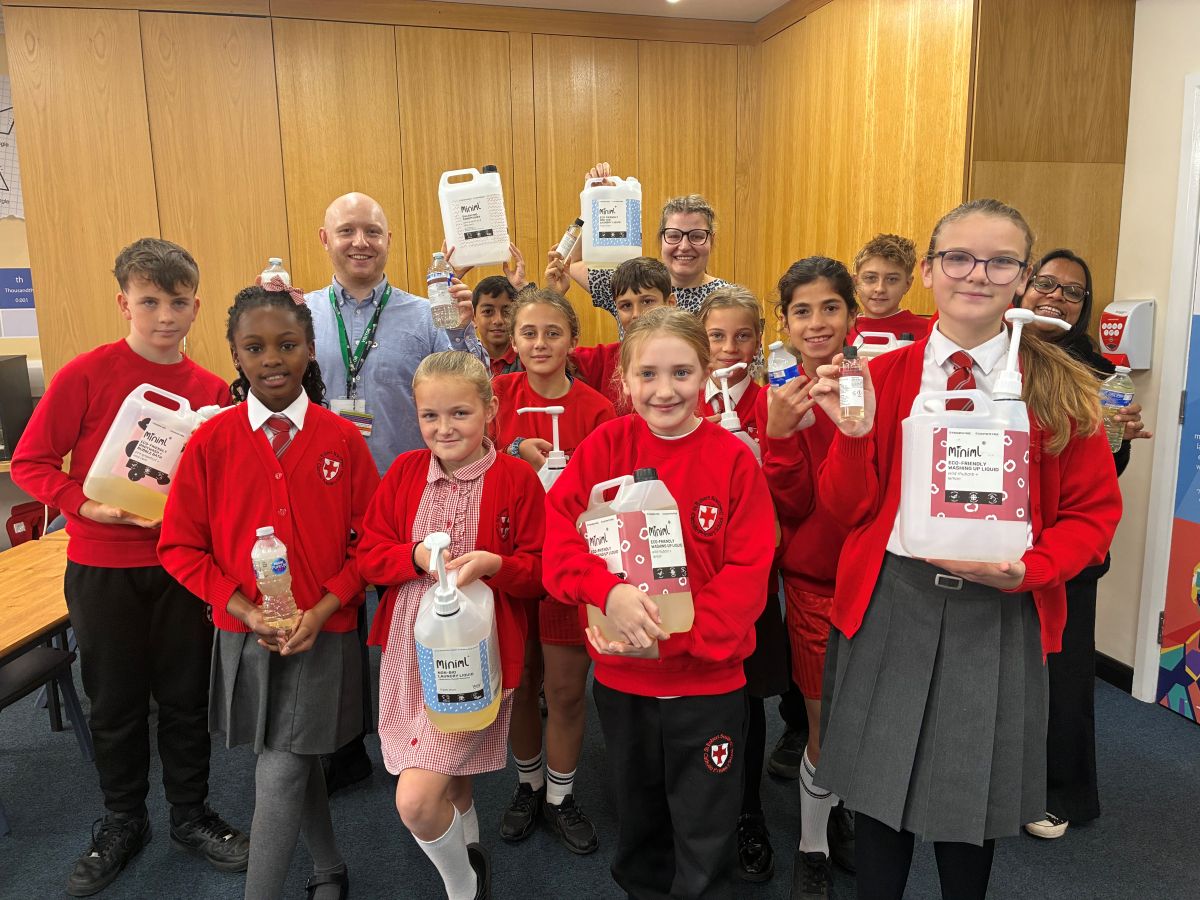 A teacher and class of pupils showing off their Eco-Refill shop products