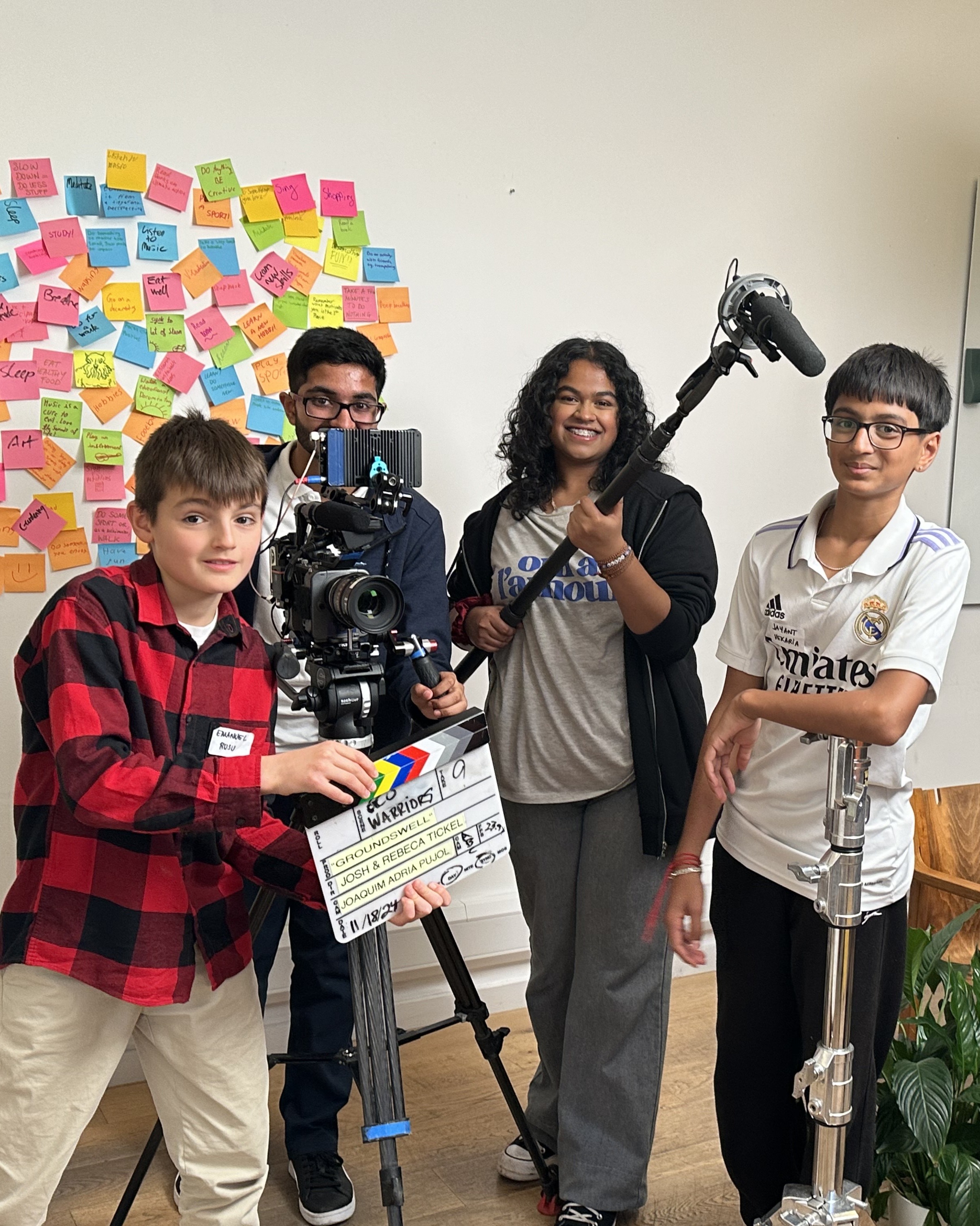 four young people directing and filming a video