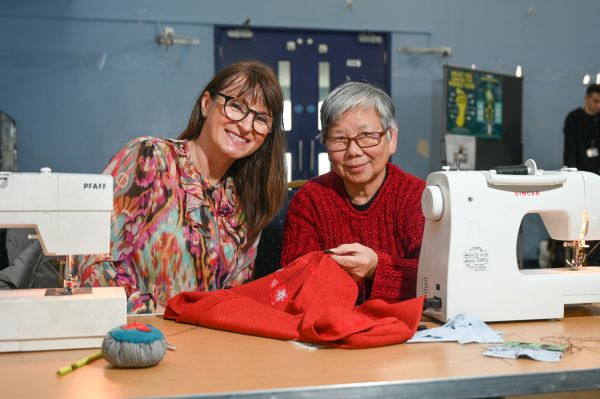 Monika Kafarska from TRAID and Lee Tan repair clothes