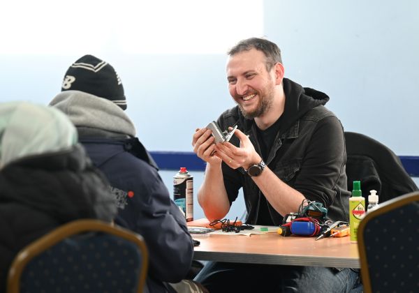 Repair man chats with resident with broken phone