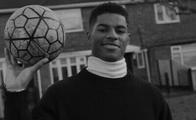 Exhibition - From the Ground up. Image of Marcus Rashford holding a football. 