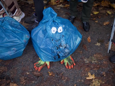 A rubbish bag with googly eyes and garden gloves as feet