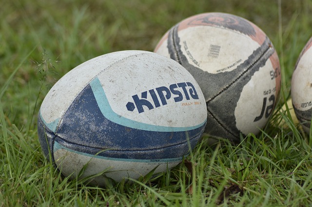 two rugby balls on a pitch