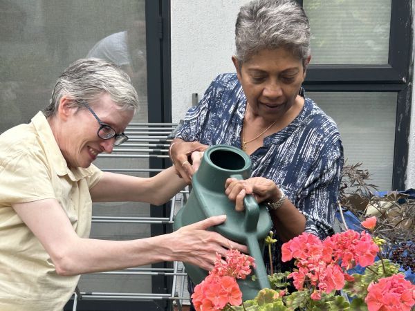 Carer helping adult water plants